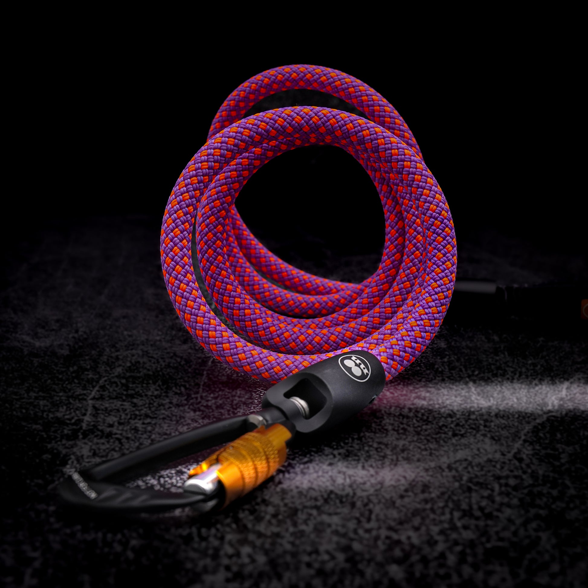 Pink and purple Mammut rope dog leash with auto-locking carabiner on dark background