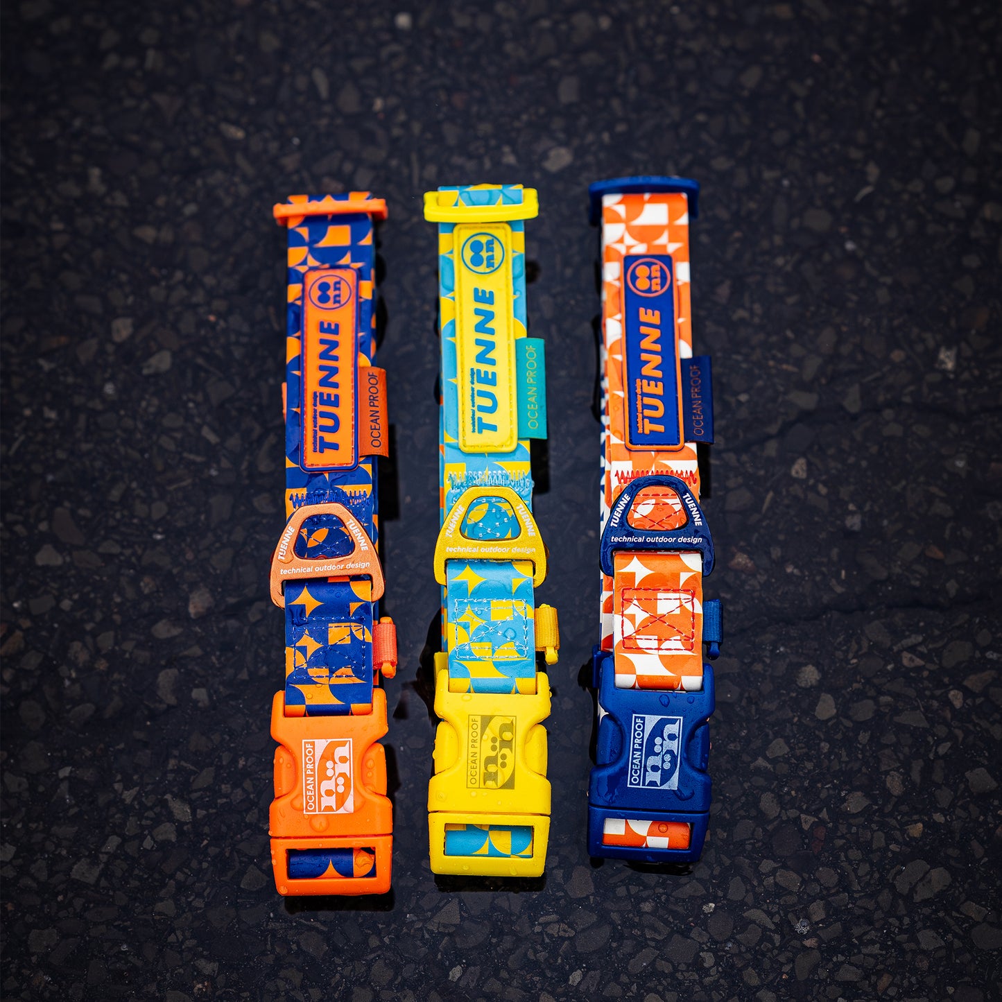 Three colorful dog collars with visible branding on a dark textured background