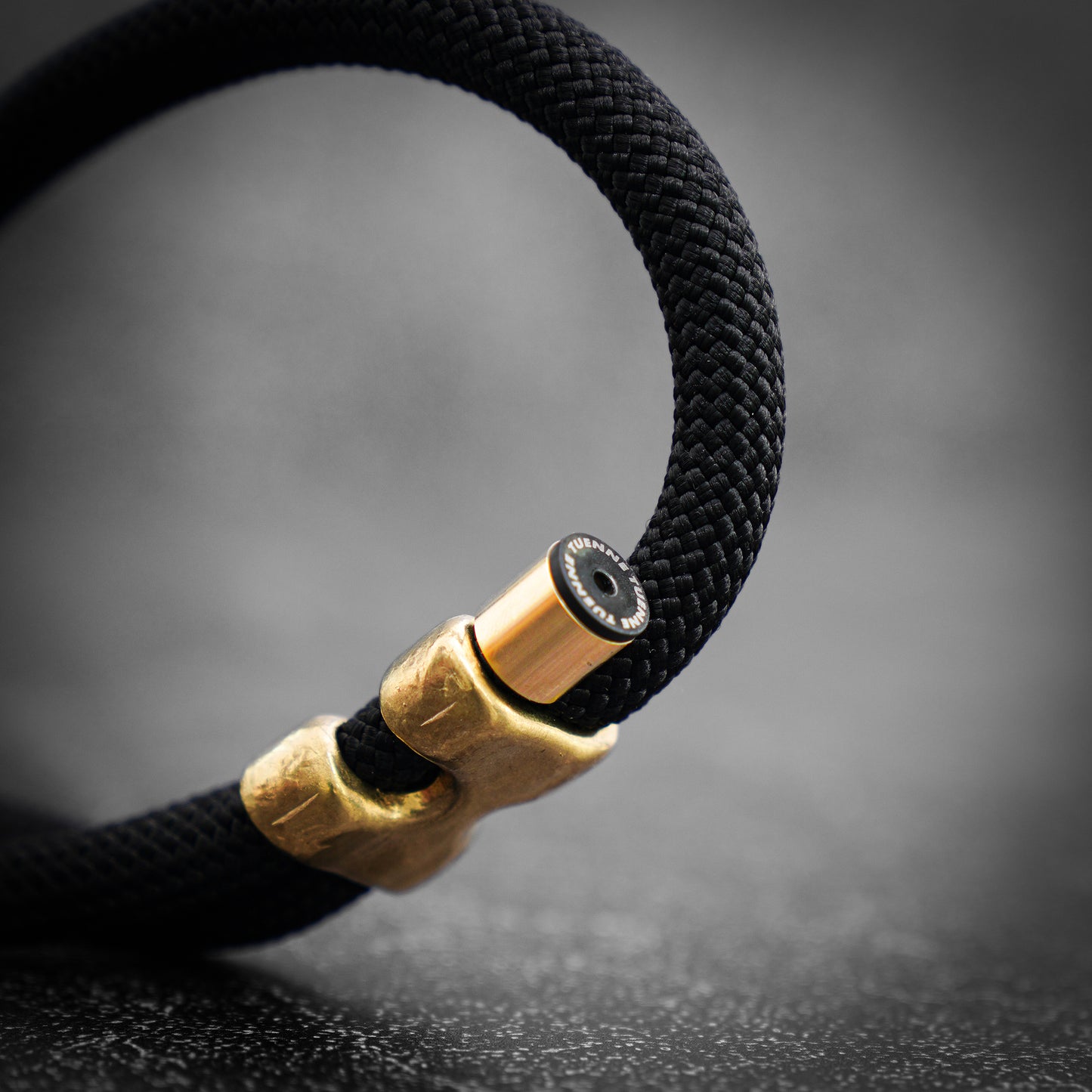 Black rope with brass clasp on a dark background