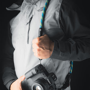 Tuenne camera strap attached to DSLR with Peak Design clips blue green strap