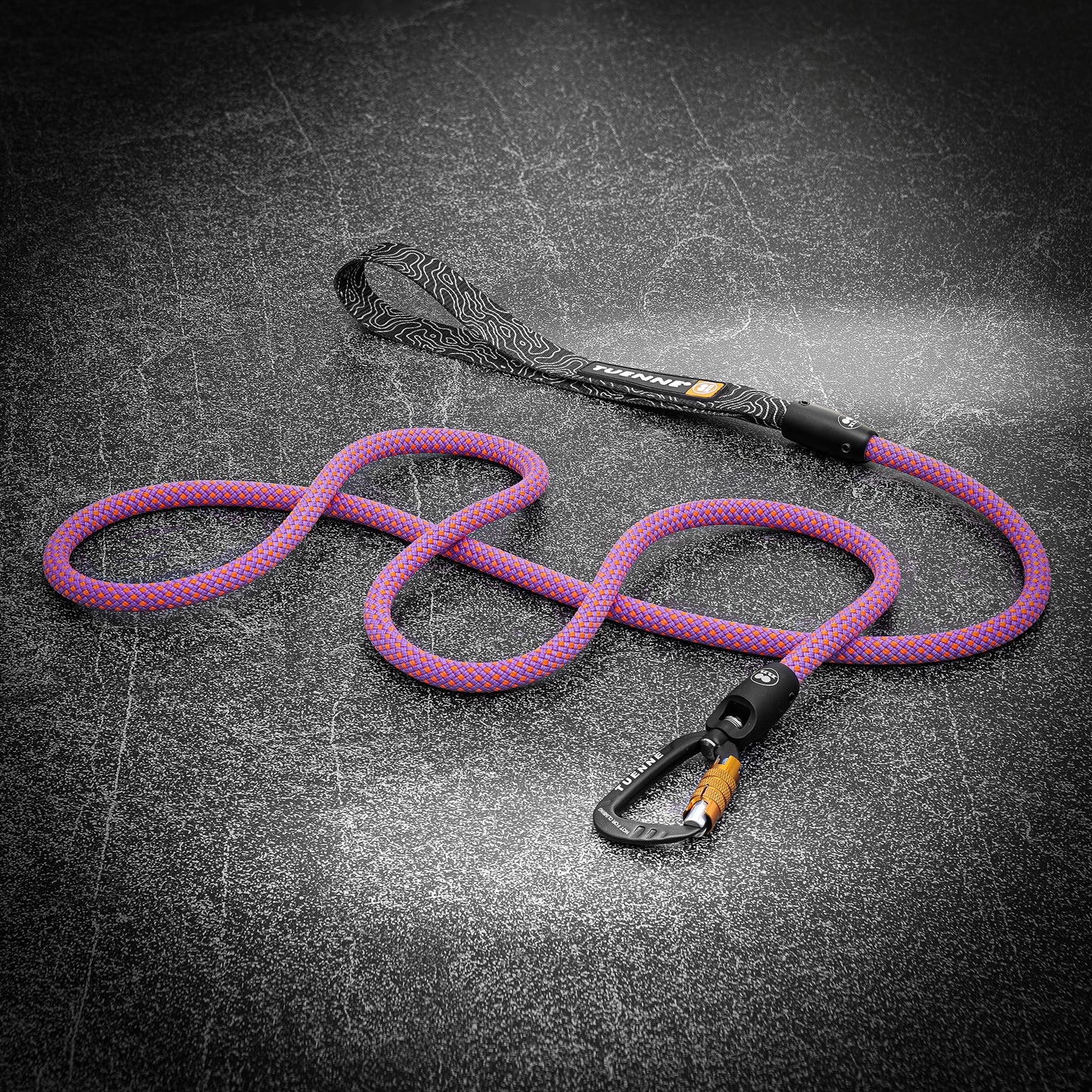 Pink and purple climbing-rope dog leash with auto-locking carabiner, laid out on dark textured surface