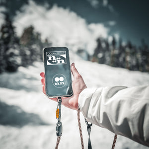 Person holding Tuenne lanyard with phone attachment on a mountain, showcasing outdoor versatility