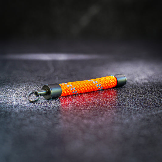 Orange rope keychain on a dark textured surface