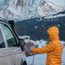 Person in the mountains using a Tuenne lanyard with a car key attached, showcasing outdoor versatility